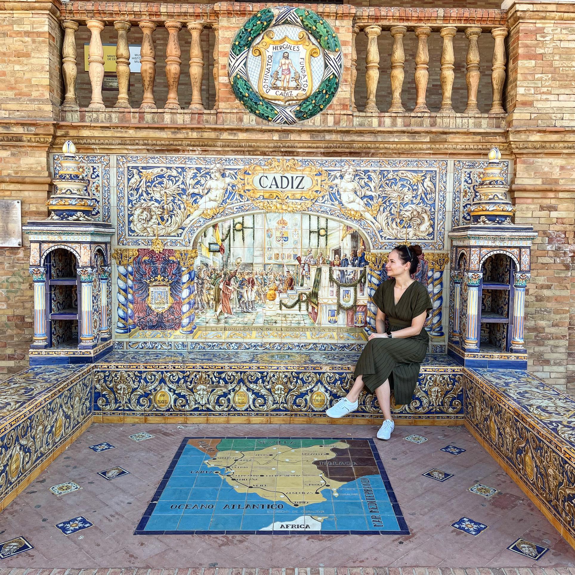 A woman sitting on a tiled bench wall